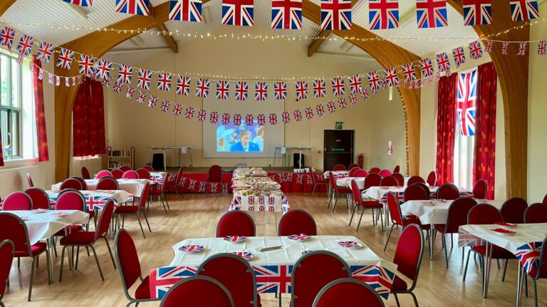 Inside of the hall, with tables arranged for a party